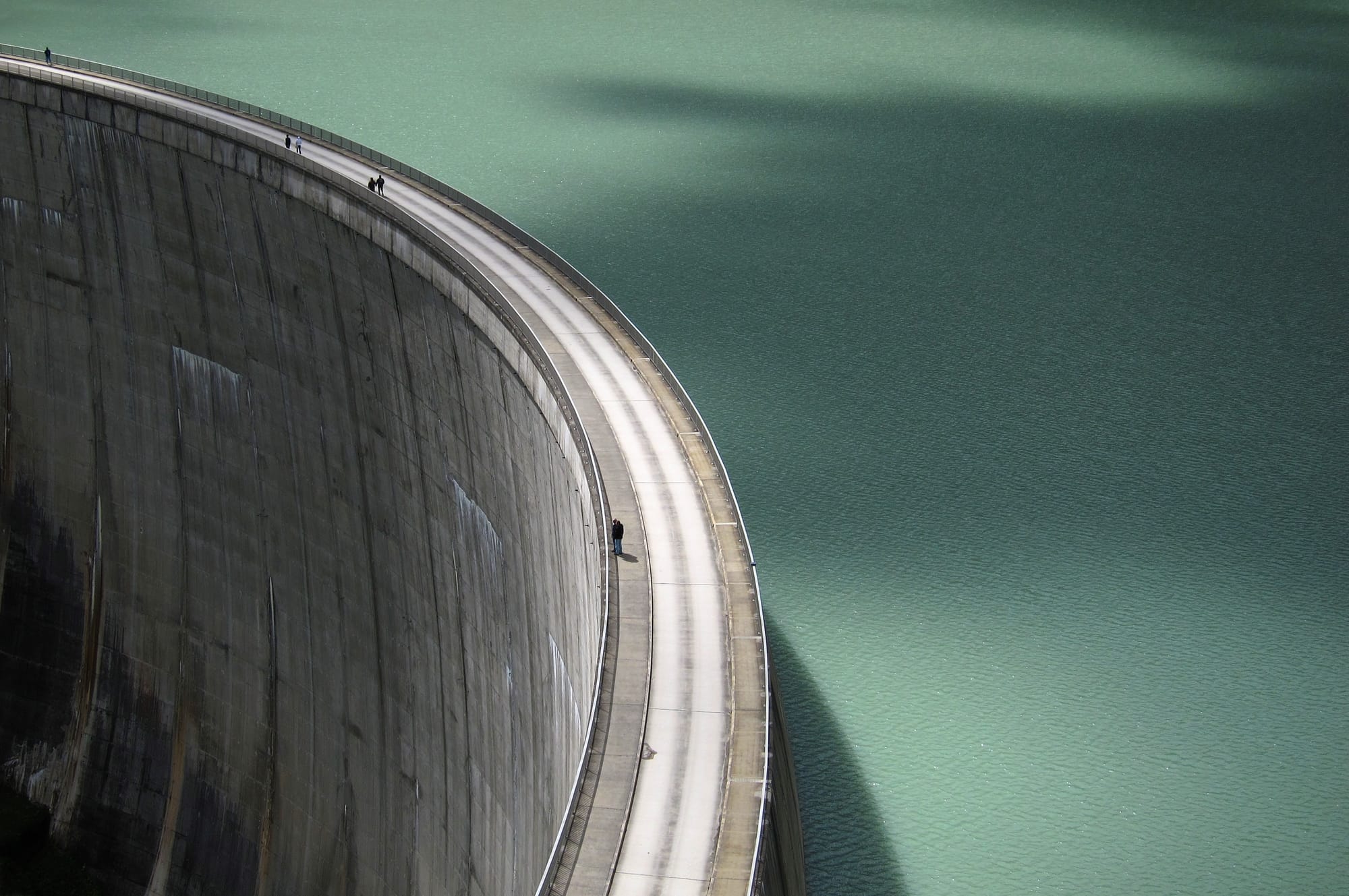 A walkway over an industrial mining tailings dam at dusk